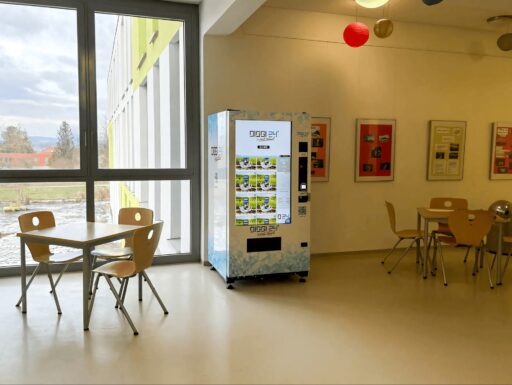DIGGI 24 Snackautomat in einem Schul-Pausenraum mit Holztischen